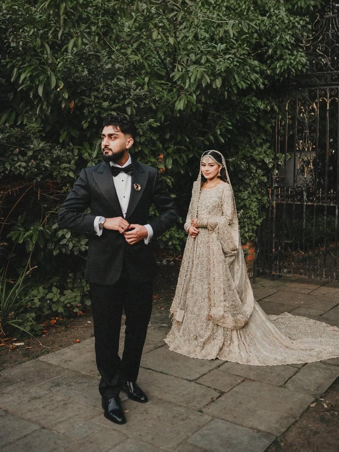 An Asian wedding couple by the estate's iron gates