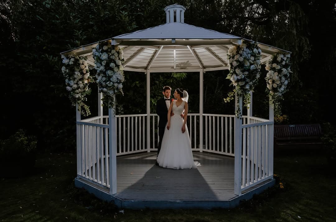 Newlyweds beneath the floral gazebo in the Secret Garden