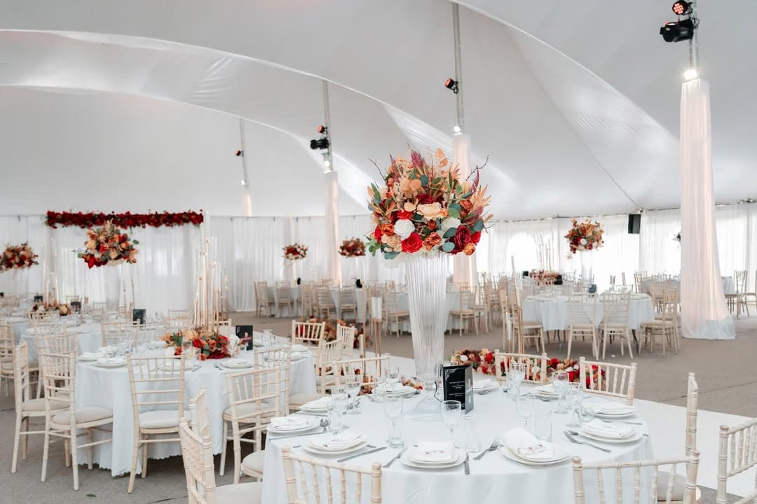 Autumnal red florals and tablescapes beneath the marquee canopy