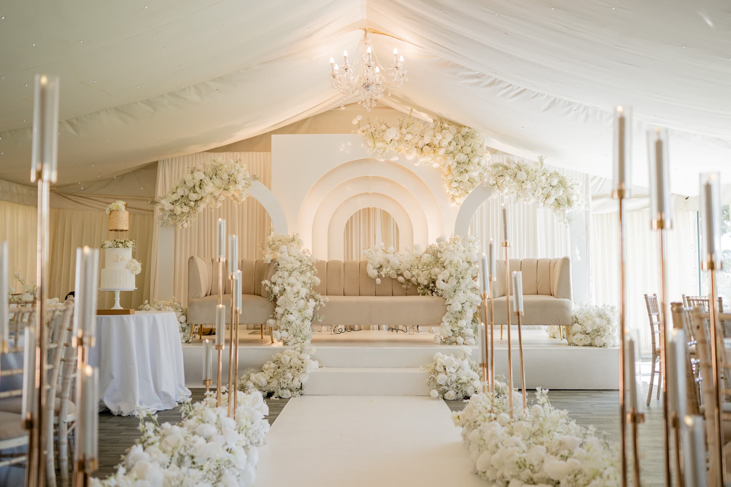 The Mini Marquee dressed for a wedding, a floral aisle leading to the arched stage