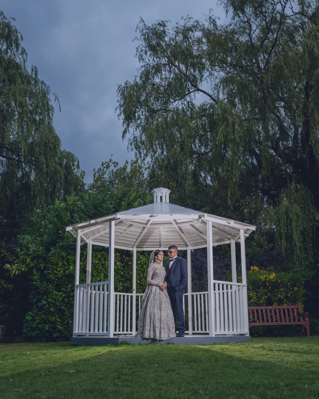 A couple beneath the Secret Garden gazebo at dusk