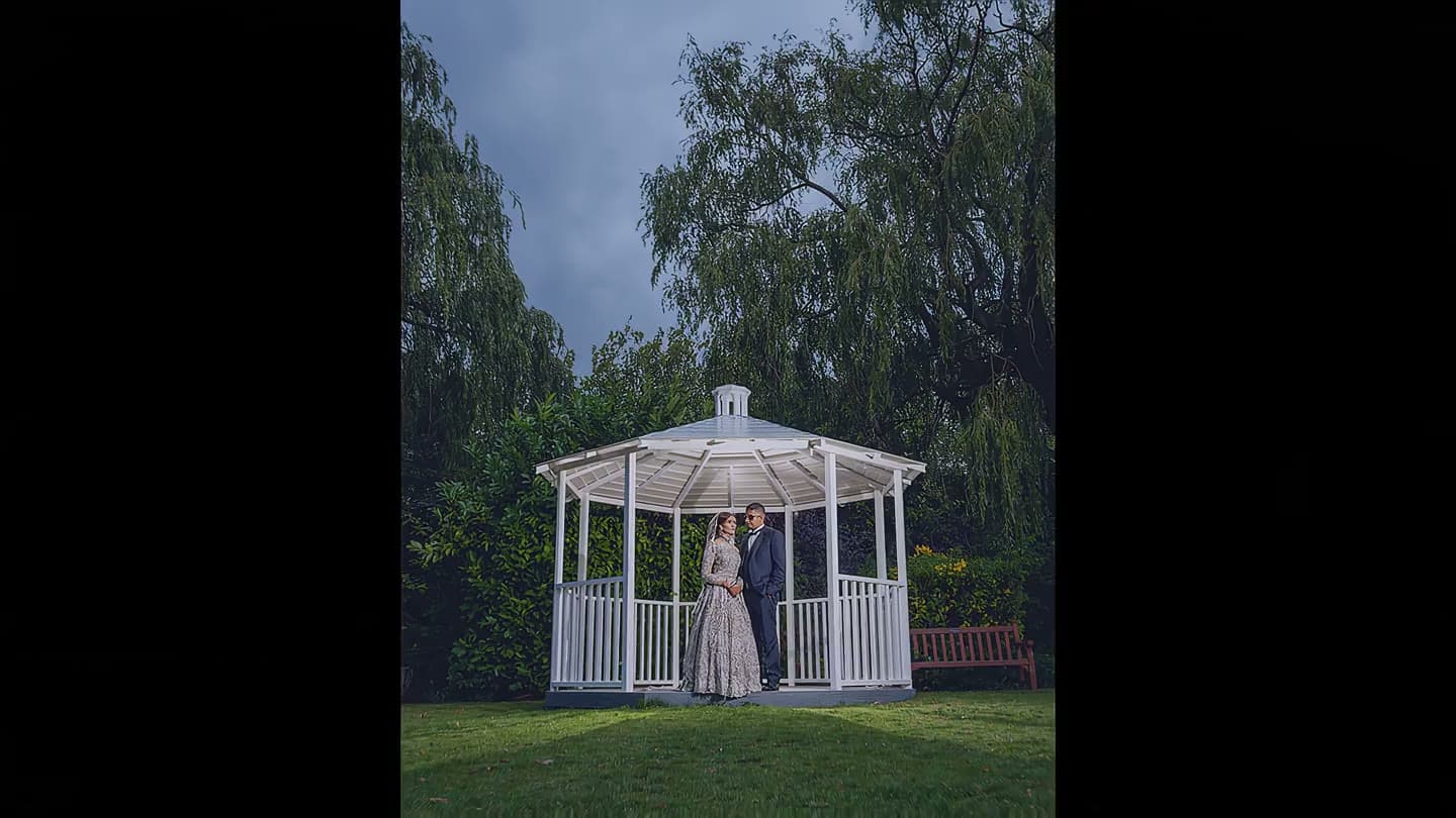 A marquee wedding ceremony aisle leading to a floral arch