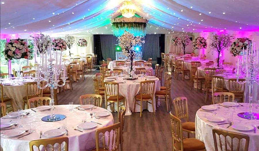 A wedding reception dressed beneath the marquee canopy